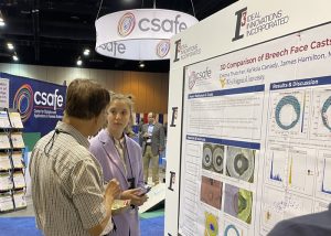 REU intern Emma Thatcher (right) talks with a conference attendee about her research during the poster session.