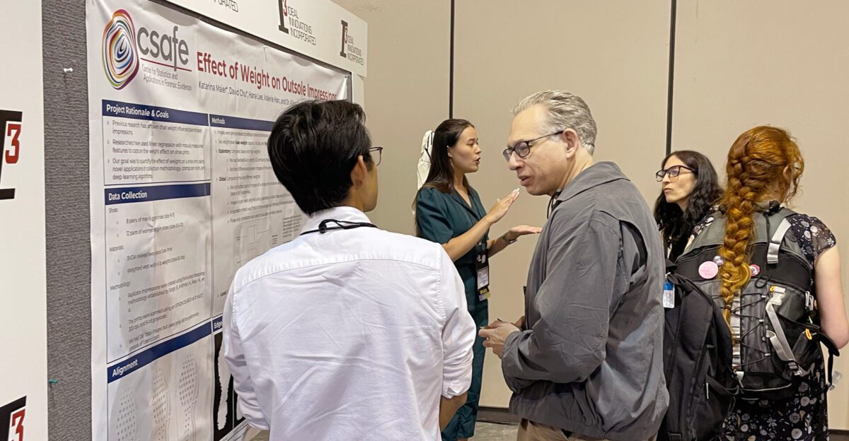 Four people discuss a research poster titled "Effect of Weight on Outsole Impressions.