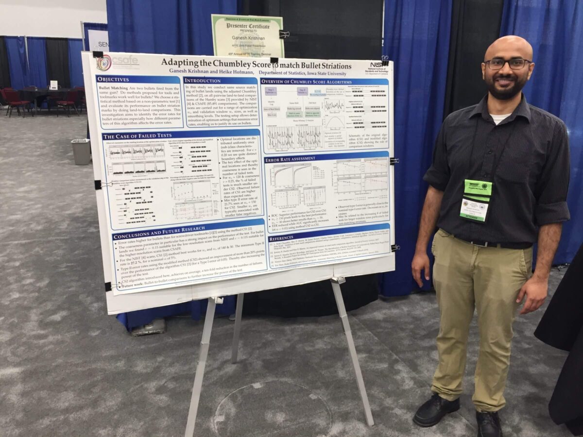Man standing next to a scientific research poster at a conference, smiling at the camera.