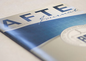 Close-up of the cover of the AFTE Journal featuring its title and a partial round logo.