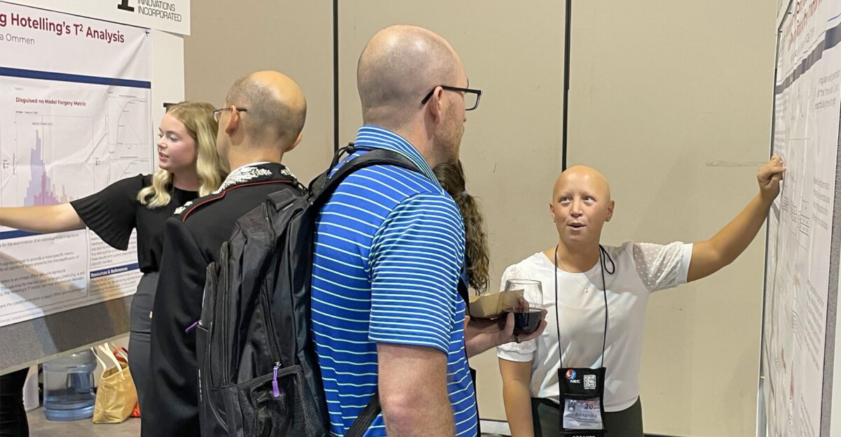 People discussing scientific posters at a conference; one woman is presenting her work.