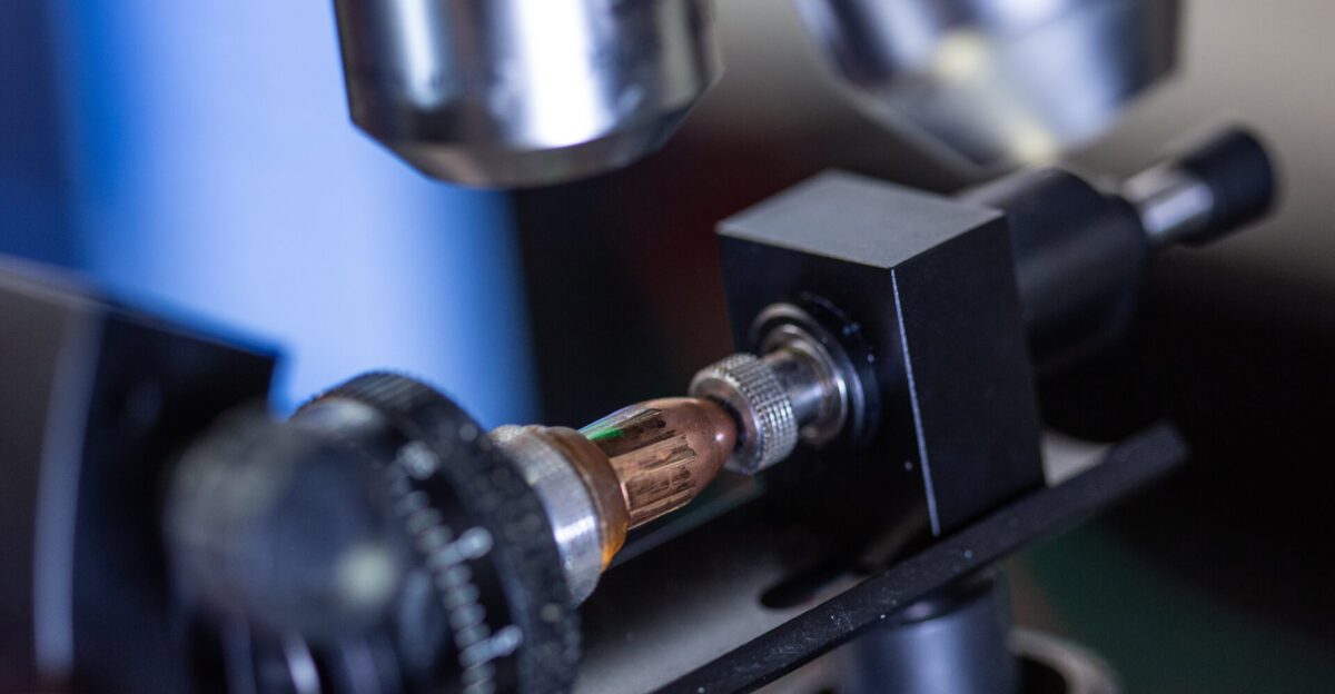 Close-up of a metal component under a microscope or scientific instrument.