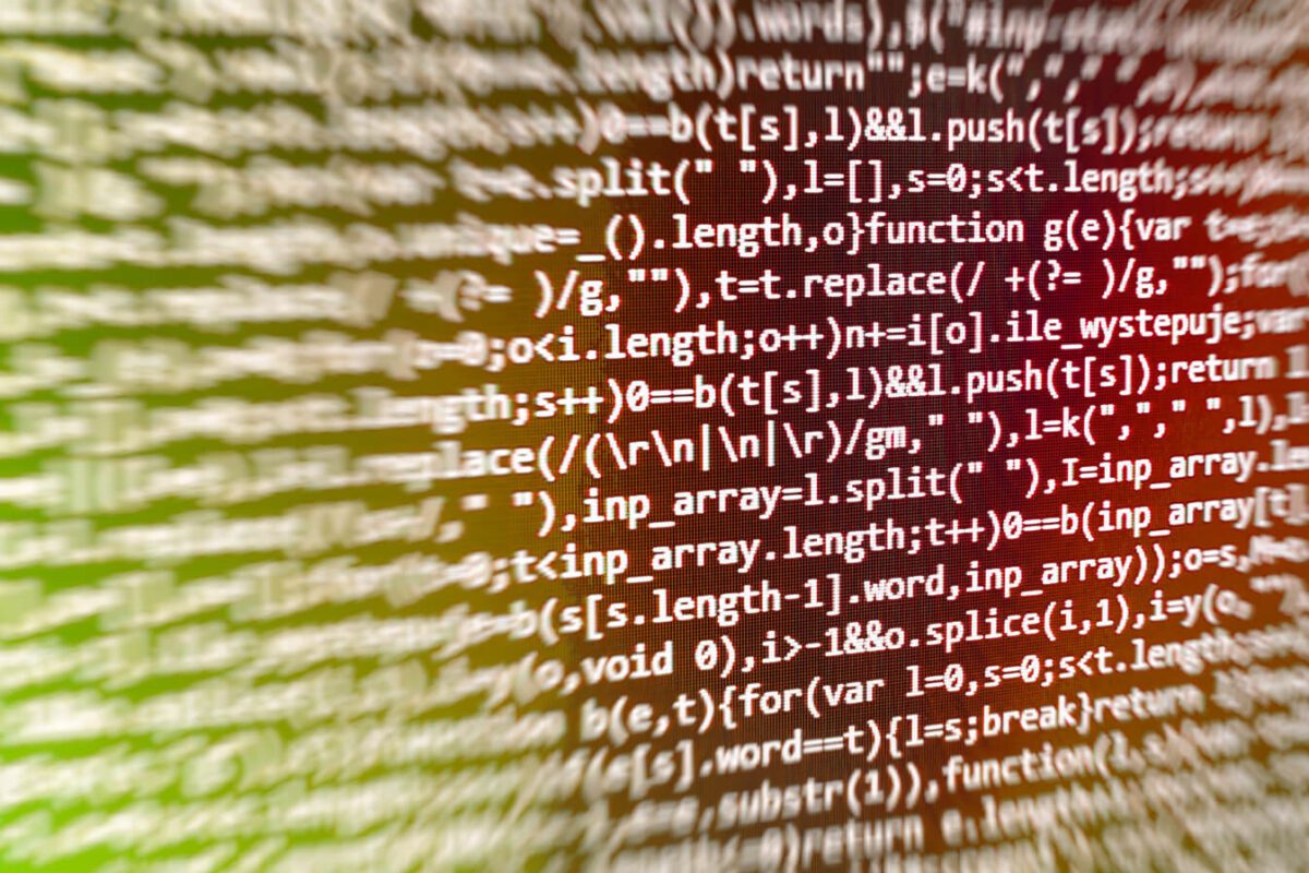 Blurry lines of computer code displayed on a screen with a green and orange gradient background.