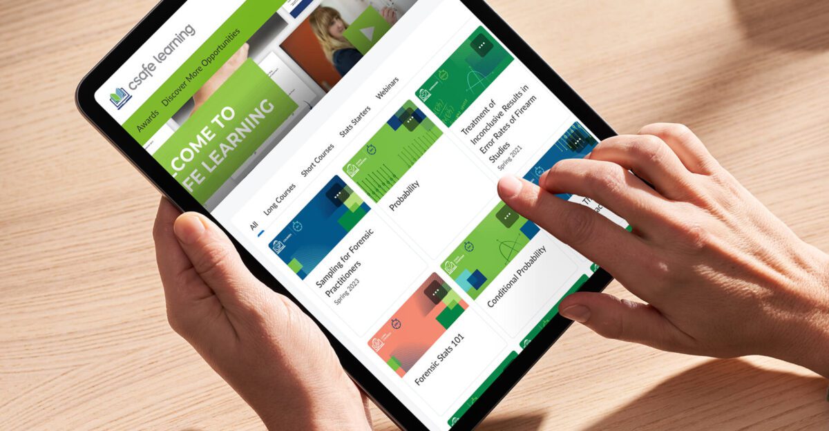 Person using a tablet to browse an online learning platform with various course options displayed.