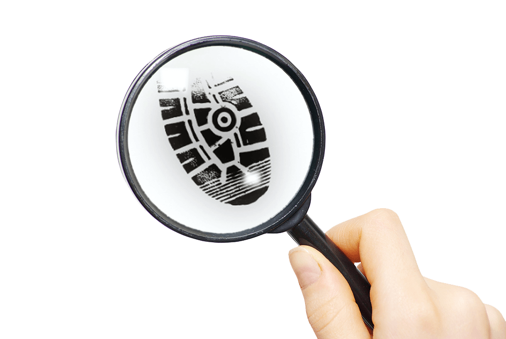 A hand holds a magnifying glass enlarging a black shoeprint pattern on a white background.