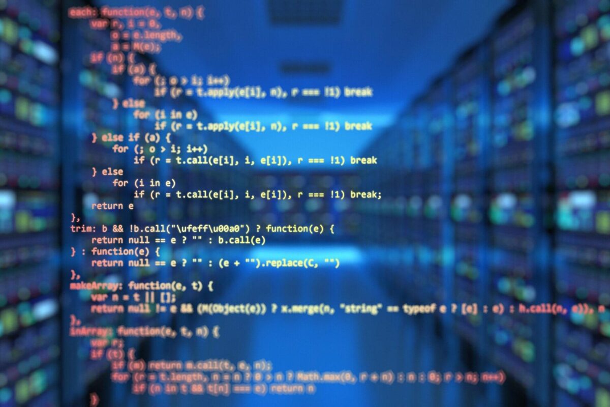 Computer code is overlaid on a blurred image of server racks in a data center.