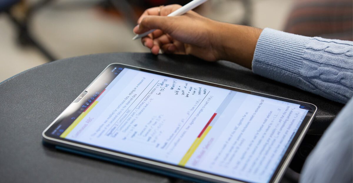 Person writing with a stylus on a tablet displaying handwritten notes and highlighted text.