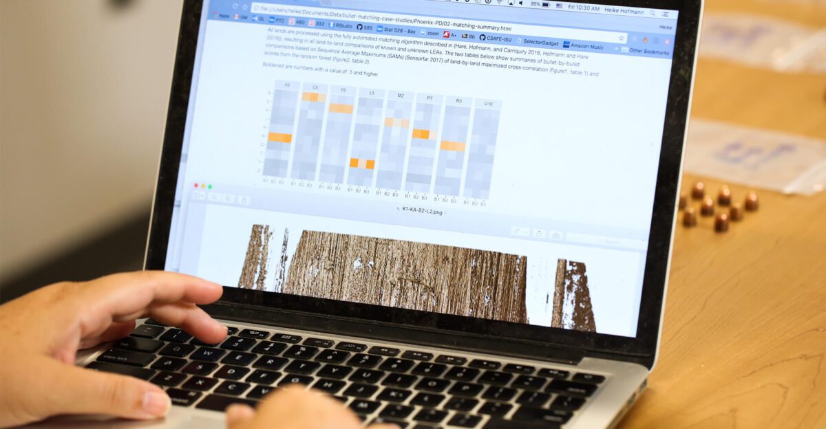 Person using a laptop displaying data visualizations and graphs on the screen.
