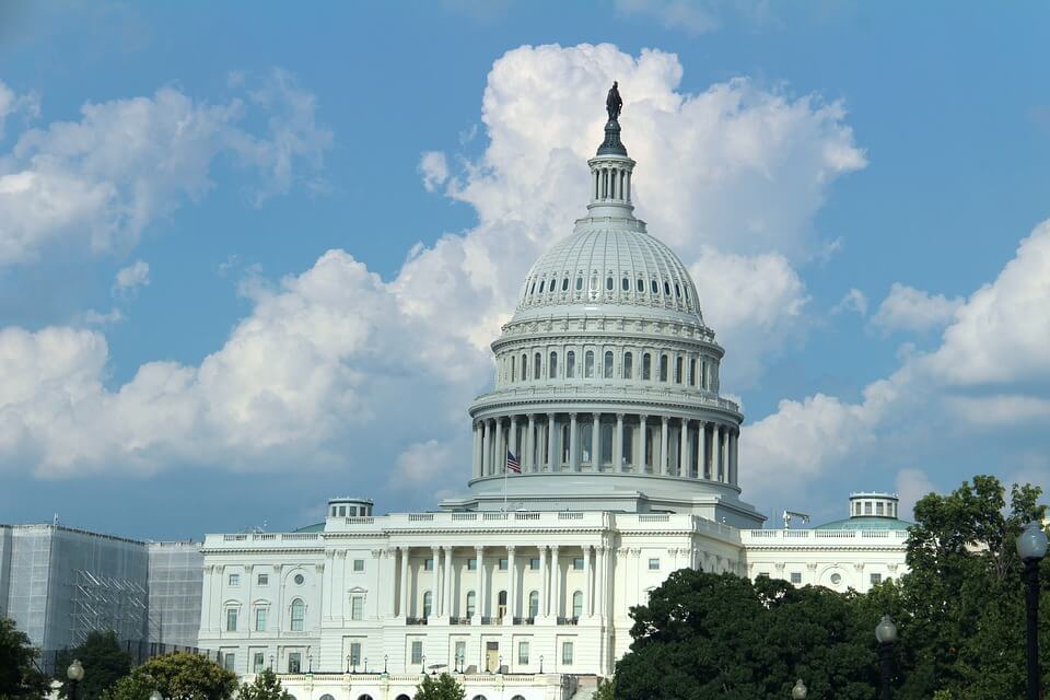 The United States Capitol building with a blue sky and white clouds in the background.